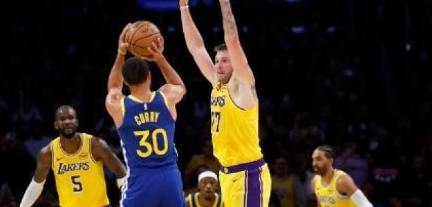 Luka Doncic, intentando taponar a Stephen Curry