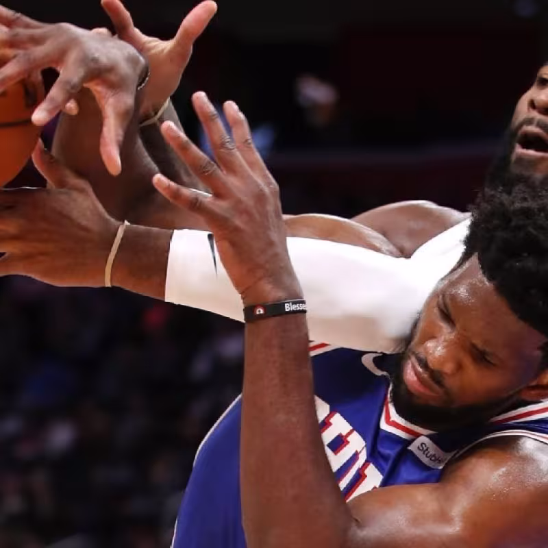 Andre Drummond y Joel Embiid disputando una posesión.