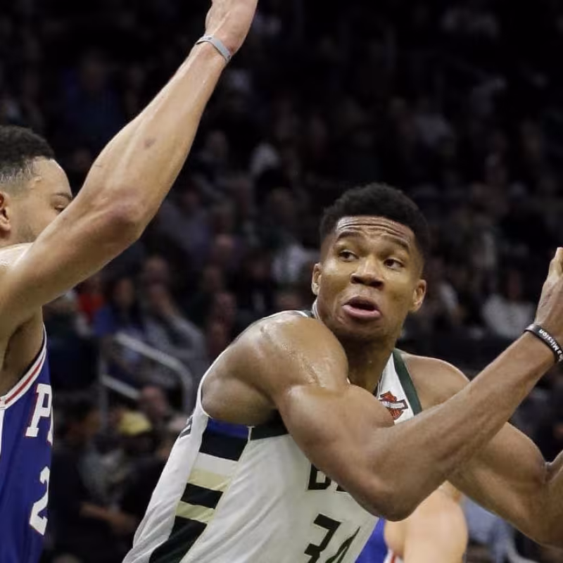 Giannis Antetokounmpo es defendido por Ben Simmons.