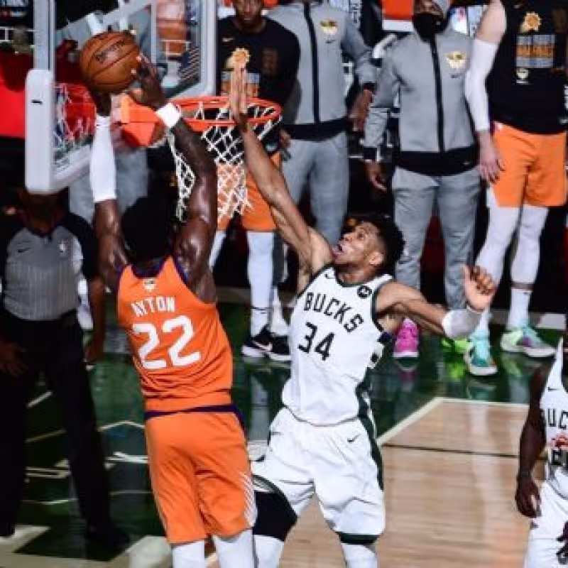 Giannis Antokounmpo, taponando a Deandre Ayton.