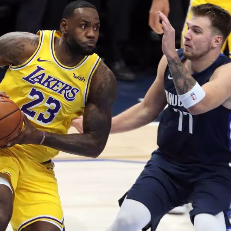 Luka Doncic intenta defender a LeBron James.