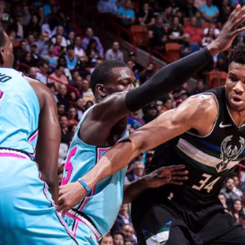 Giannis Antetokounmpo intenta anotar ante dos defensores de Miami Heat. 