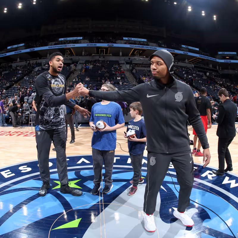 Damian Lillard y Karl-Anthony Towns saludándose.