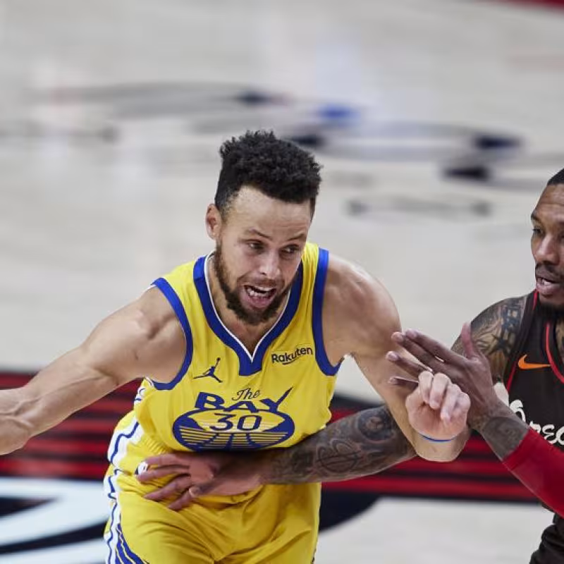 Stephen Curry, frente a Damian Lillard en un Warriors-Blazers.