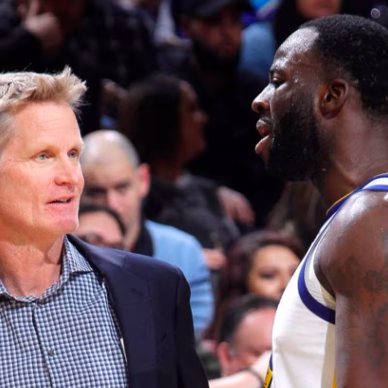 Steve Kerr conversa con Draymond Green durante un partido.