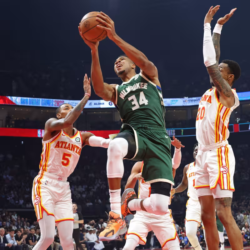 Giannis Antetokounmpo, defendido por Dejounte Murray y John Collins