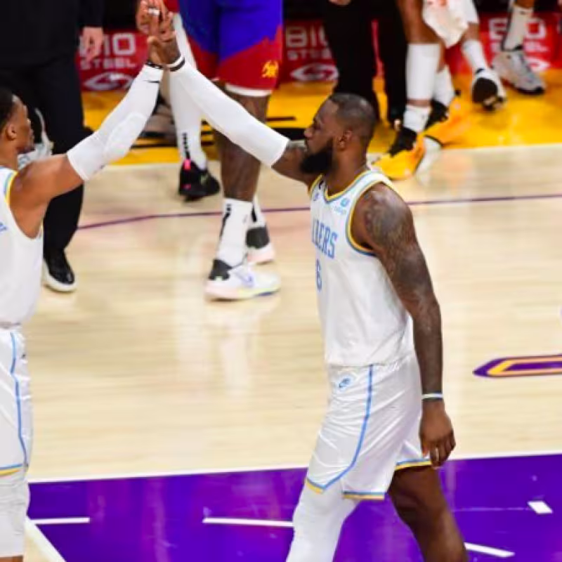 Russell Westbrook y LeBron James celebran una canasta.