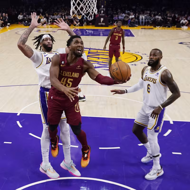 Donovan Mitchell entrando a canasta delante de Anthony Davis y LeBron James