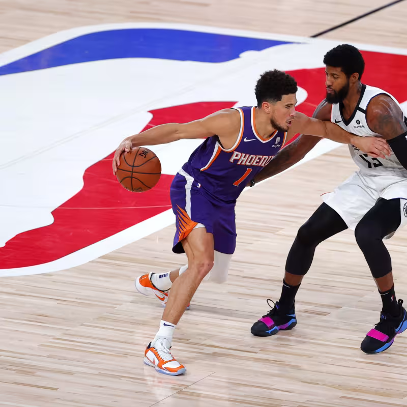 Devin Booker, defendido por Paul George