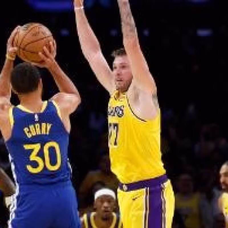 Luka Doncic attempting to block Stephen Curry