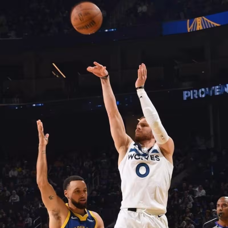 Donte DiVincenzo, tirando por encima de Stephen Curry