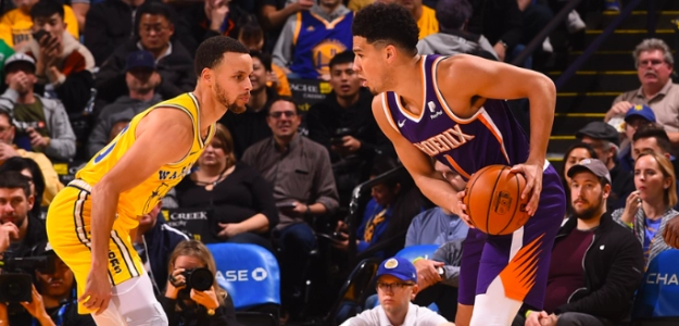 Devin Booker, ante Stephen Curry durante el Suns-Warriors.