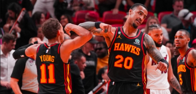 John Collins y Trae Young celebran una canasta ante los Heat. 