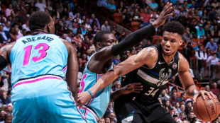 Giannis Antetokounmpo intenta anotar ante dos defensores de Miami Heat. 