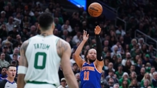 Jalen Brunson shooting to the basket under the watchful eye of Jayson Tatum.